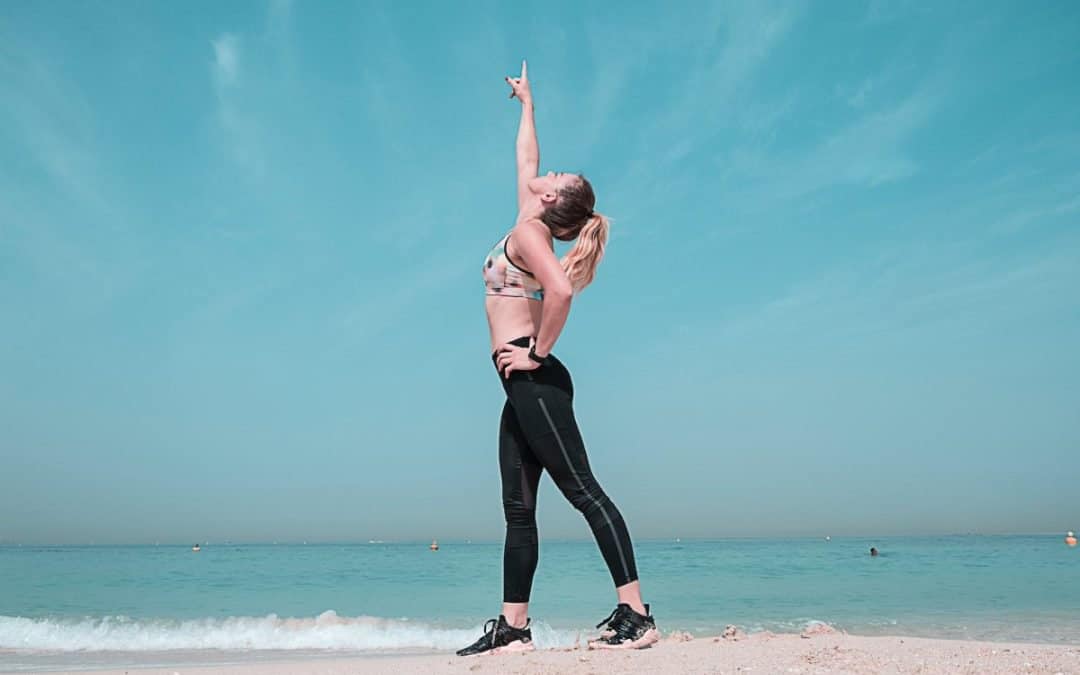 woman pointing at sky on seashore