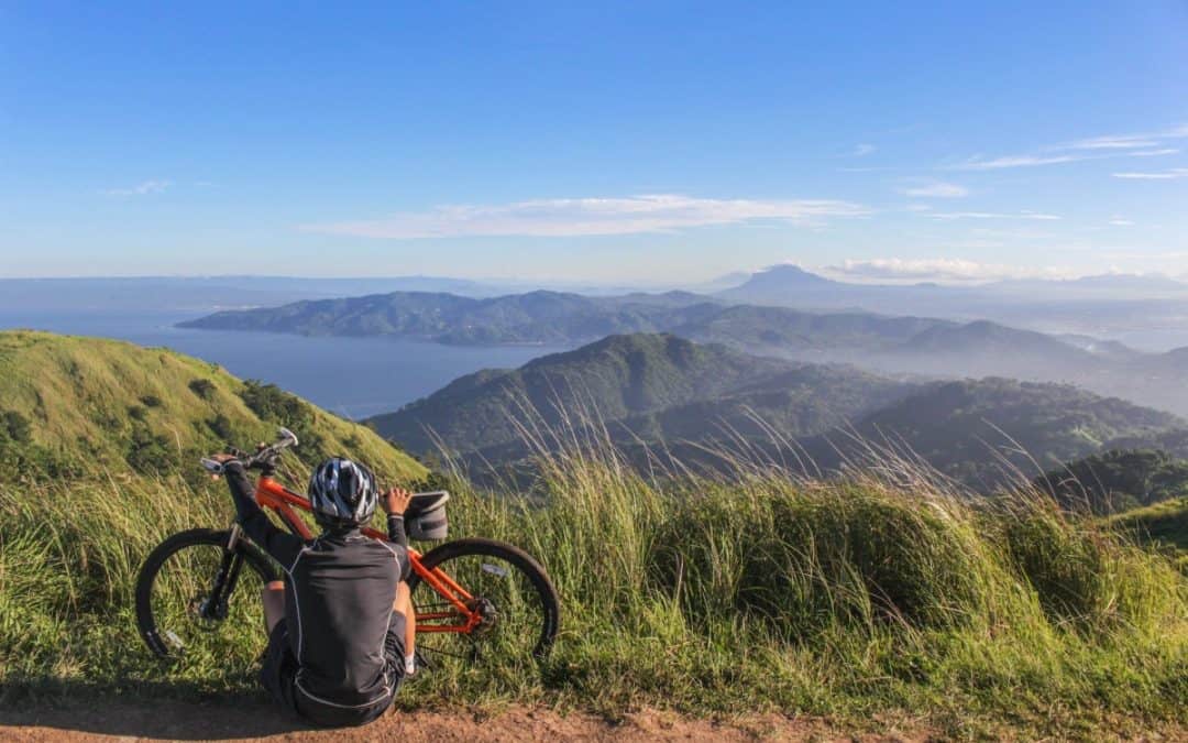 man sitting beside bicycle