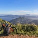 man sitting beside bicycle