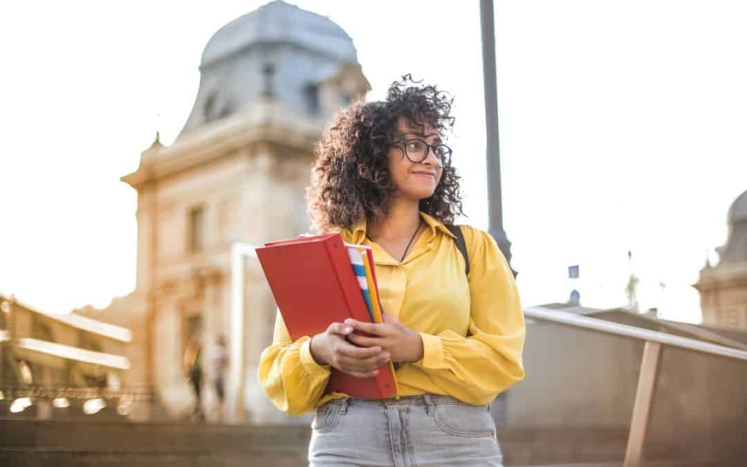 woman in yellow jacket holding books