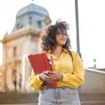 woman in yellow jacket holding books