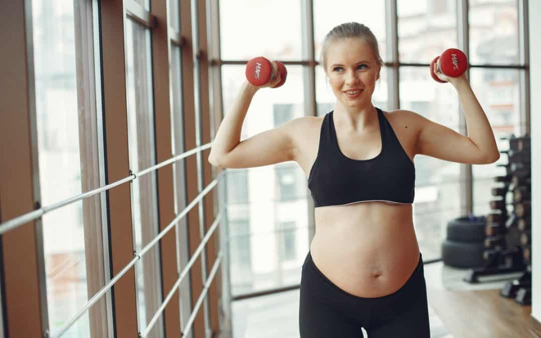 woman in black sports bra and black shorts holding red kettle bell