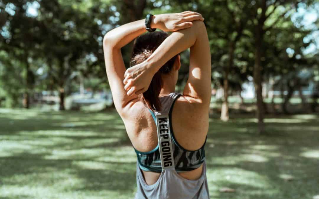 unrecognizable female athlete stretching muscles of arms and back