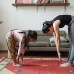 photo of woman and girl stretching their body