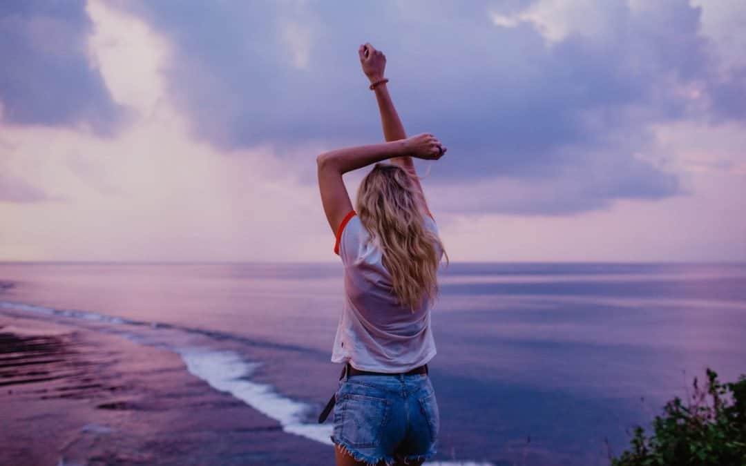 slim woman enjoying endless seascape on beach