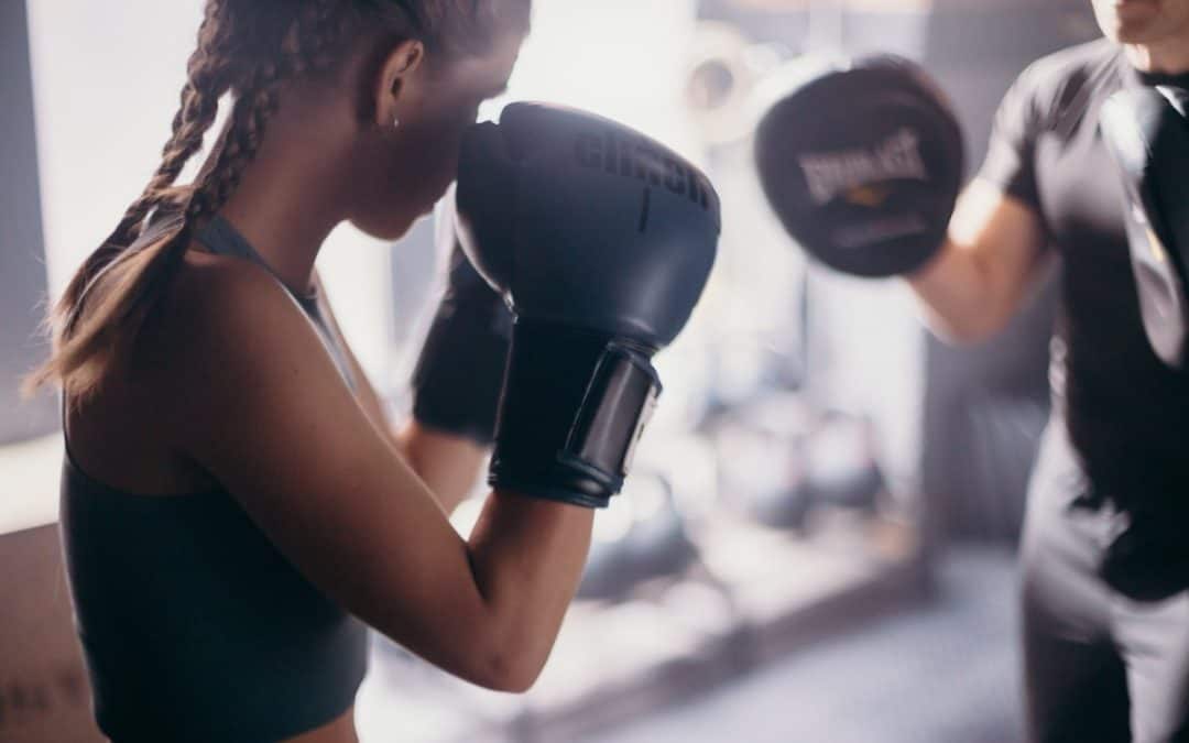 woman in black tank top wearing black boxing gloves