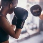 woman in black tank top wearing black boxing gloves