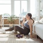 woman drinking water while sitting on the floor